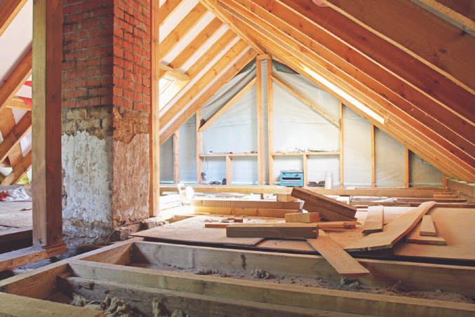 A loft being converted with the sun shining through a gap in the roof