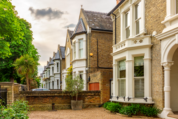A row of houses all with white bay front windows